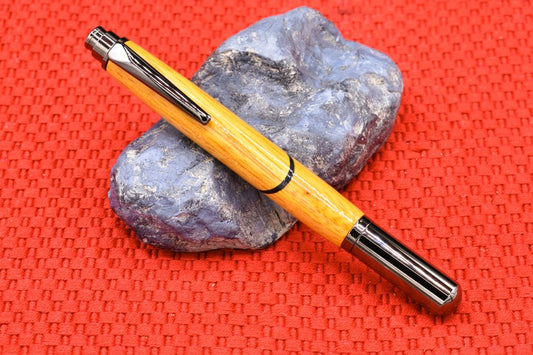 Handmade Click capped rollerball pen. Osage Orange and blue veneer woods.