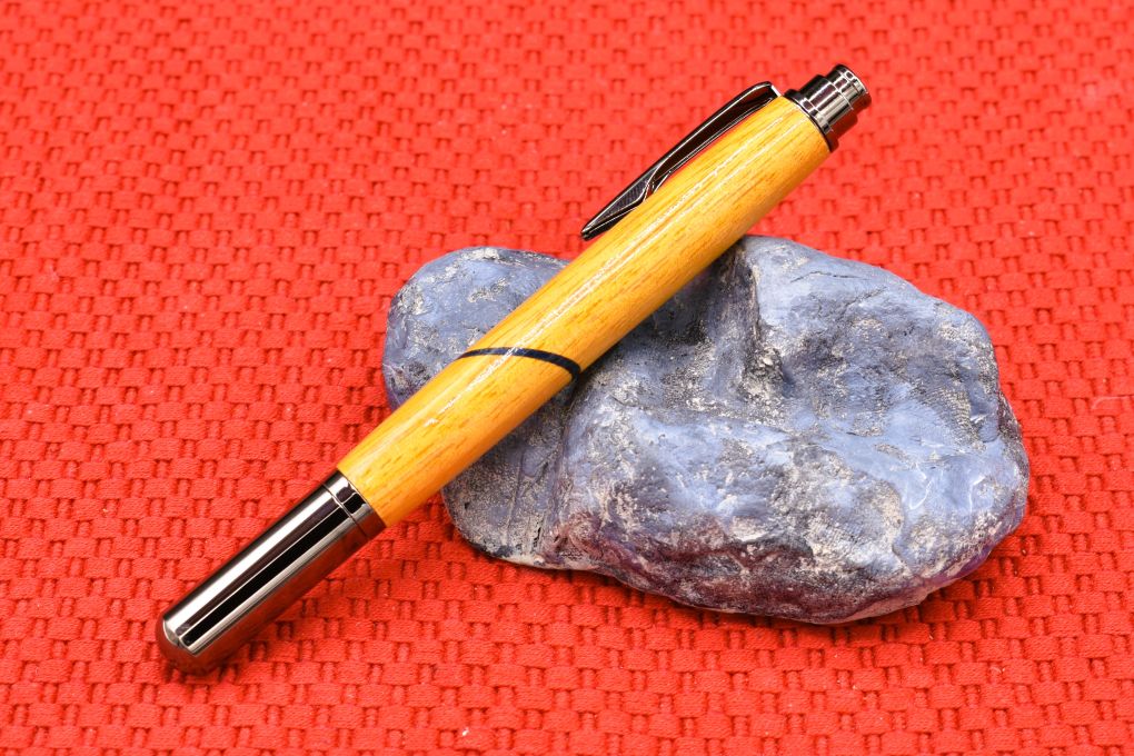 Handmade Click capped rollerball pen. Osage Orange and blue veneer woods.