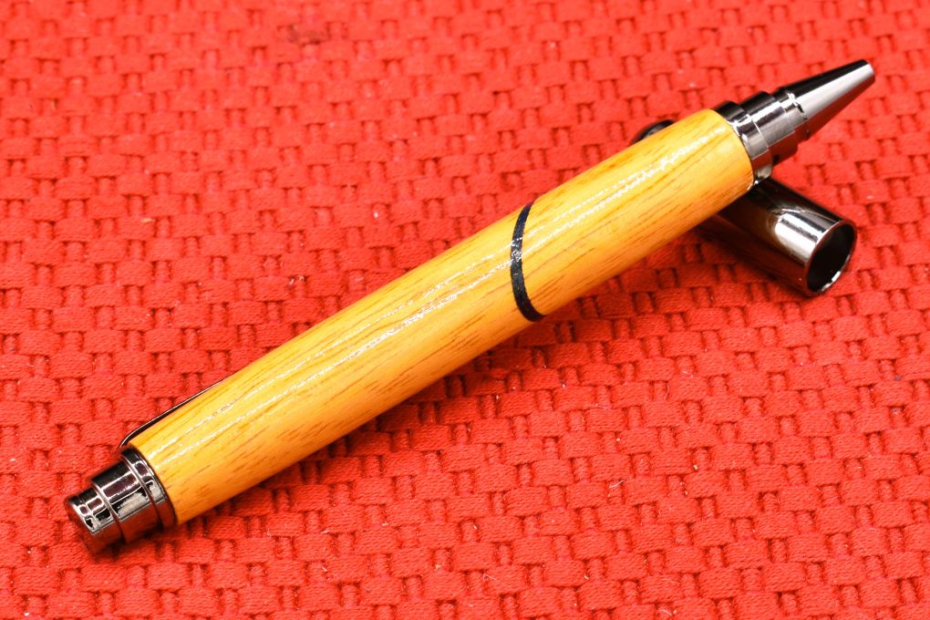 Handmade Click capped rollerball pen. Osage Orange and blue veneer woods.